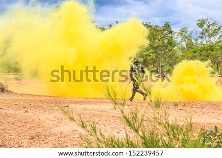soldier running behind yellow smoke screen