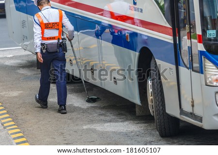 MANILA - FEB 12: Unidentified security guards check the bus at Diamond Hotel on 12 Feb, 14 in Manila. It is estimated 3.7 million of security guards including doormen in the Philippines.