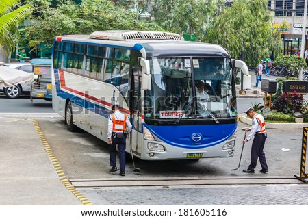 MANILA - FEB 12: Unidentified security guards check the bus at Diamond Hotel on 12 Feb, 14 in Manila. It is estimated 3.7 million of security guards including doormen in the Philippines.