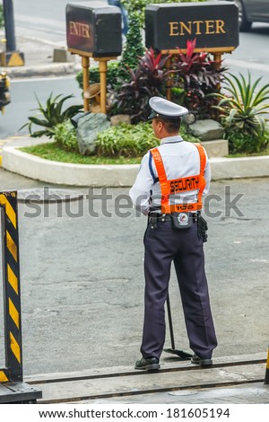 MANILA - FEB 12: Unidentified security guard at Diamond Hotel on 12 Feb, 14 in Manila. It is estimated 3.7 million of security guards including doormen in the Philippines.