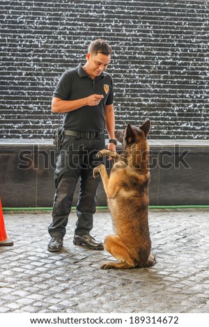 MANILA - FEB 12: Unidentified security guard with dog at Diamond Hotel on 12 Feb, 14 in Manila. It is estimated 3.7 million of security guards including doormen in the Philippines.