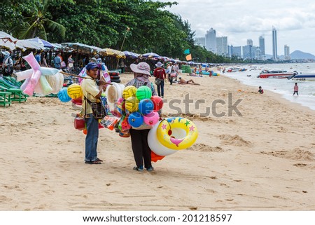 PATTAYA, THAILAND - SEP 15: Local merchant sell swim tubes to tourists at Pattay beach on Sep 15, 13, it is a city in Thailand, a beach resort popular with tourists and expatriates.
