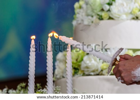 bride and groom candling with the backgrond of wedding cake