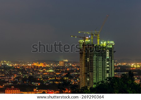 Building crane and building under construction at twilight