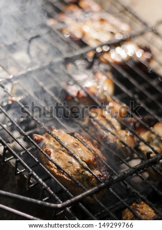 Barbecue in the forest.shashlik at nature.Process of cooking meat on barbecue, closeup.Barbecue with meat in metal grate