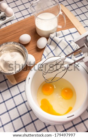 Ingredients for cooking breakfast on the table, and broken egg yolks in a bowl like a fun smiley face