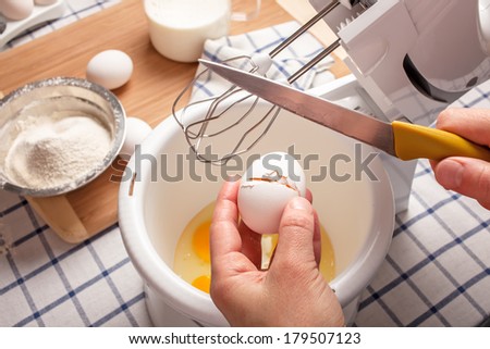 ingredients for dough on the table and cook breaks egg in a cup for mixer