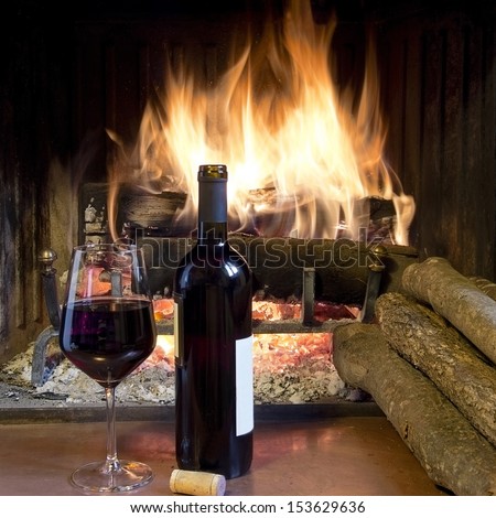 Celebrate With A Glass Of Wine, A Bottle, In Front Of A Fireplace