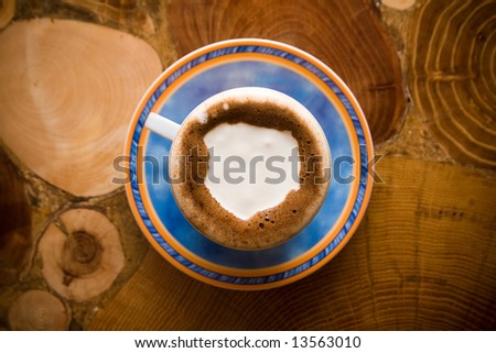 Coffee with milk on wooden table from top