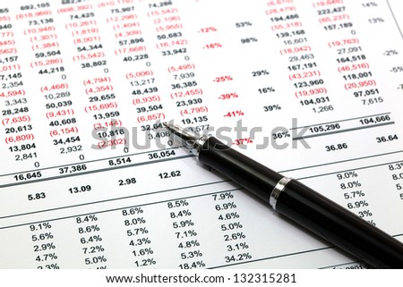 Reading finance report with pen