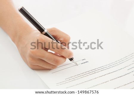 Female hand signing contract.