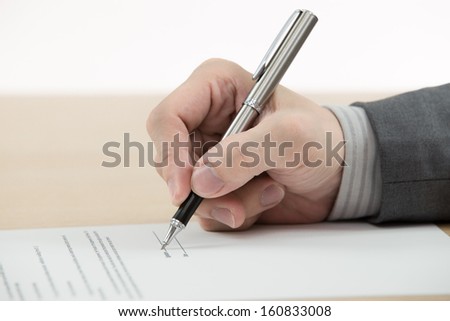 Business man signing finance contract on table