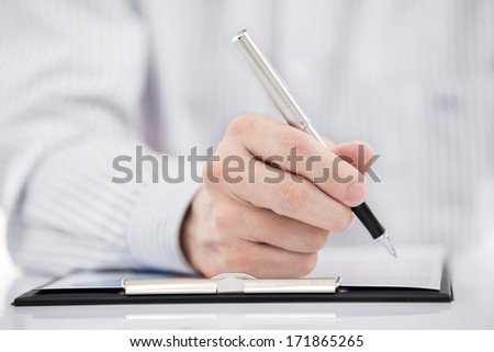 man hand with pen and business report on table
