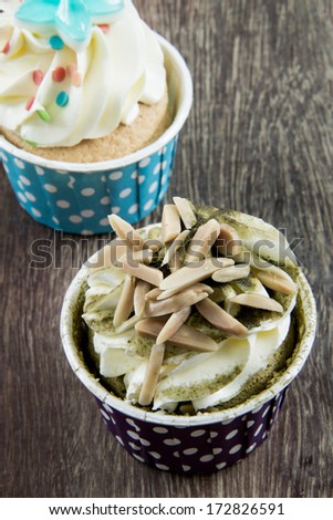 Tasty cupcake with butter cream on wood background