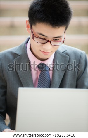 young businessman working outside with laptop
