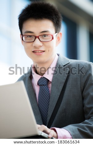 young businessman working outside with laptop