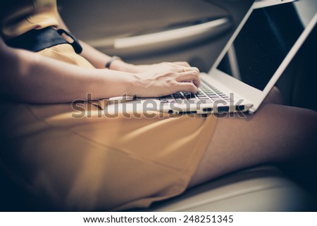businesswoman with document and laptop in car