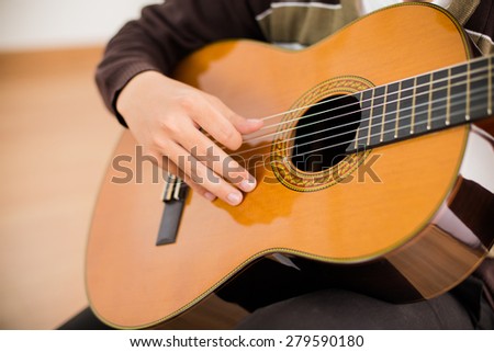 Practicing in playing guitar. Handsome young men playing guitar