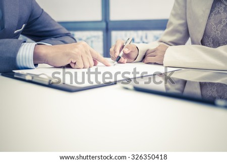 Female hand signing contract.