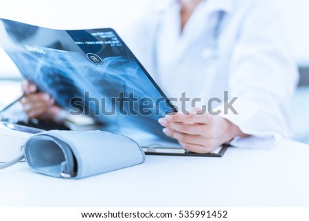 Woman Doctor Looking at X-Ray Radiography in patient's Room