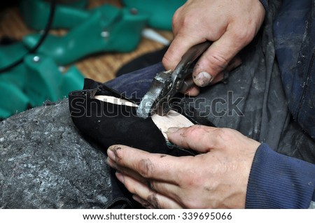 Shoemaker tools. Shoemaker workshop. Shoemaker sews shoes.