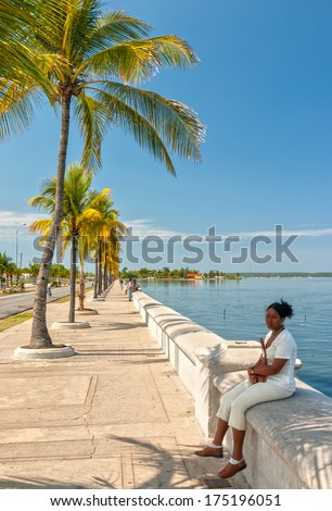 CIENFUEGOS, CUBA - MAY 5: Paseo el Prado embankment with local woman sitting shown on 5 May 2008 in Cienfuegos, Cuba