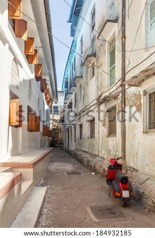 Streets in heart of Stone Town city, which mostly consists of a maze of narrow alleys lined by houses, shops, bazaars and mosques. Most streets are too narrow for cars. Located in Zanzibar, Tanzania.