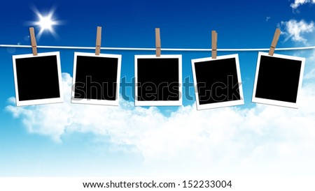 Photos frames hanging in the rope on a sky, summer day