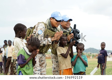 MUKJAR ,Southern Sudan - September 16, 2011 : Unidentified young African kids and mans.THAI Military Peacekeeping mission in Southern Sudan.