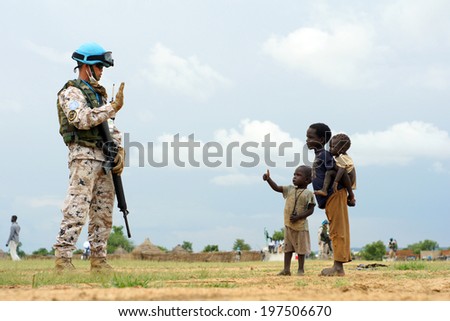 MUKJAR ,SOUTHERN SUDEN - SEPT 16, 2011 : Unidentified young African kids and mans.THAI Military Peacekeeping mission in Southern Sudan,The symbols of the kids is to ask for food.