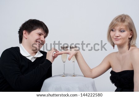 Man offering a ring to a Woman against grey background