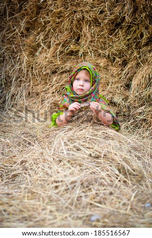 Close up image of beautiful little girl in russian village traditional kerchief with round cracknel with russian ornamen over autumn weather/Lovely russian young gir
