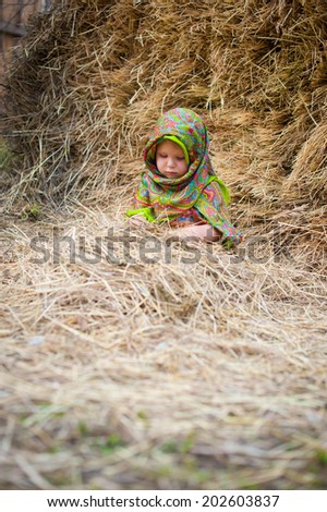 Close up image of beautiful little girl in russian village traditional kerchief with round cracknel with russian ornamen over autumn weather/Lovely russian Baby girl
