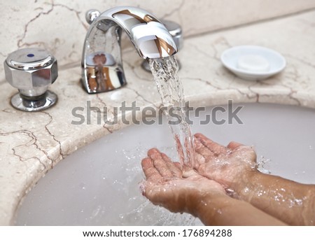 Cleanliness is the guarantee of health. Baby hands under running water