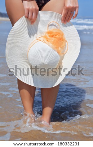 White womens hat with large fields in the hands against the sea