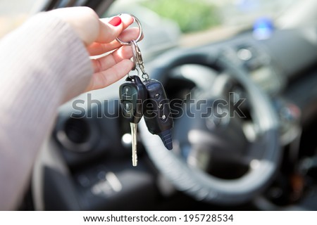 A woman\'s hand gives the keys to the car