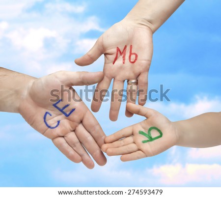 The word family written in colorful Russian letters on the palms of the father, mother and child, on a background of blue sky