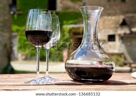 Red wine in a wine carafe and a two wine glasses in the vineyard