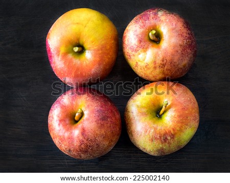 Four red apples, Belle de Boskoop, on a dark background