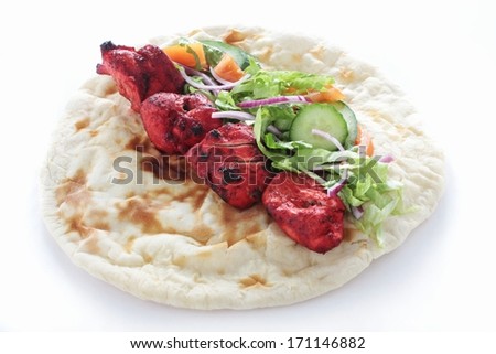 cooked indian chicken tikka kebab on naan bread