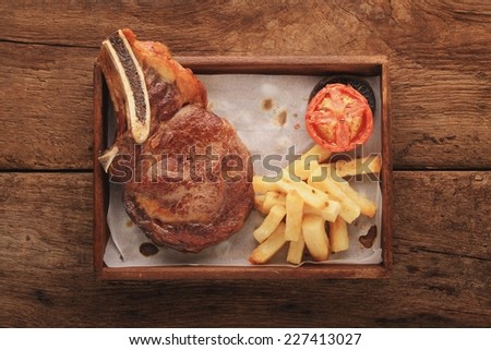 cooked large beef rib steak on tray platter