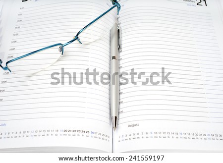 Daily planner with glasses and pen on the table