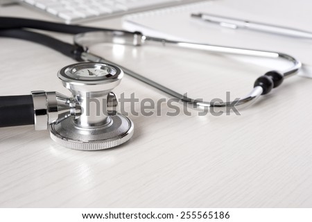 Stethoscope on doctor\'s desk with keyboard and pad