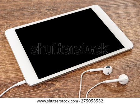 Headphones and tablet computer are on the table