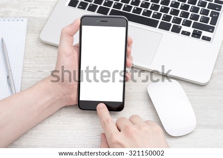 The smartphone in your hand on the table with laptop