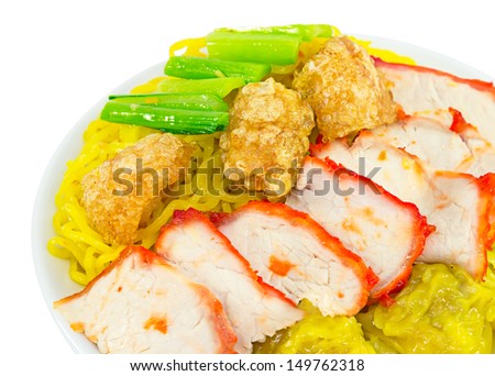 Chinese dry noodles with roast red pork, dumpling, pork scratching and vegetables in white plate.