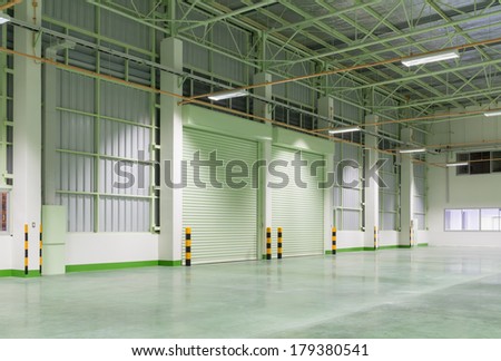 Interior of factory with shutter door, night time.