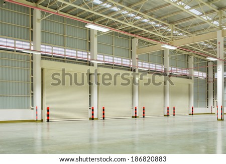 Interior of factory with shutter door, night time.