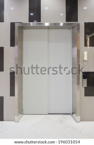 Elevator door (gray color)  with white floor.