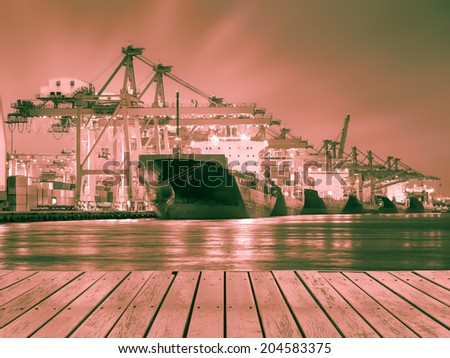 Cargo ship and crane at port reflect with river, twilight time (red color tone).